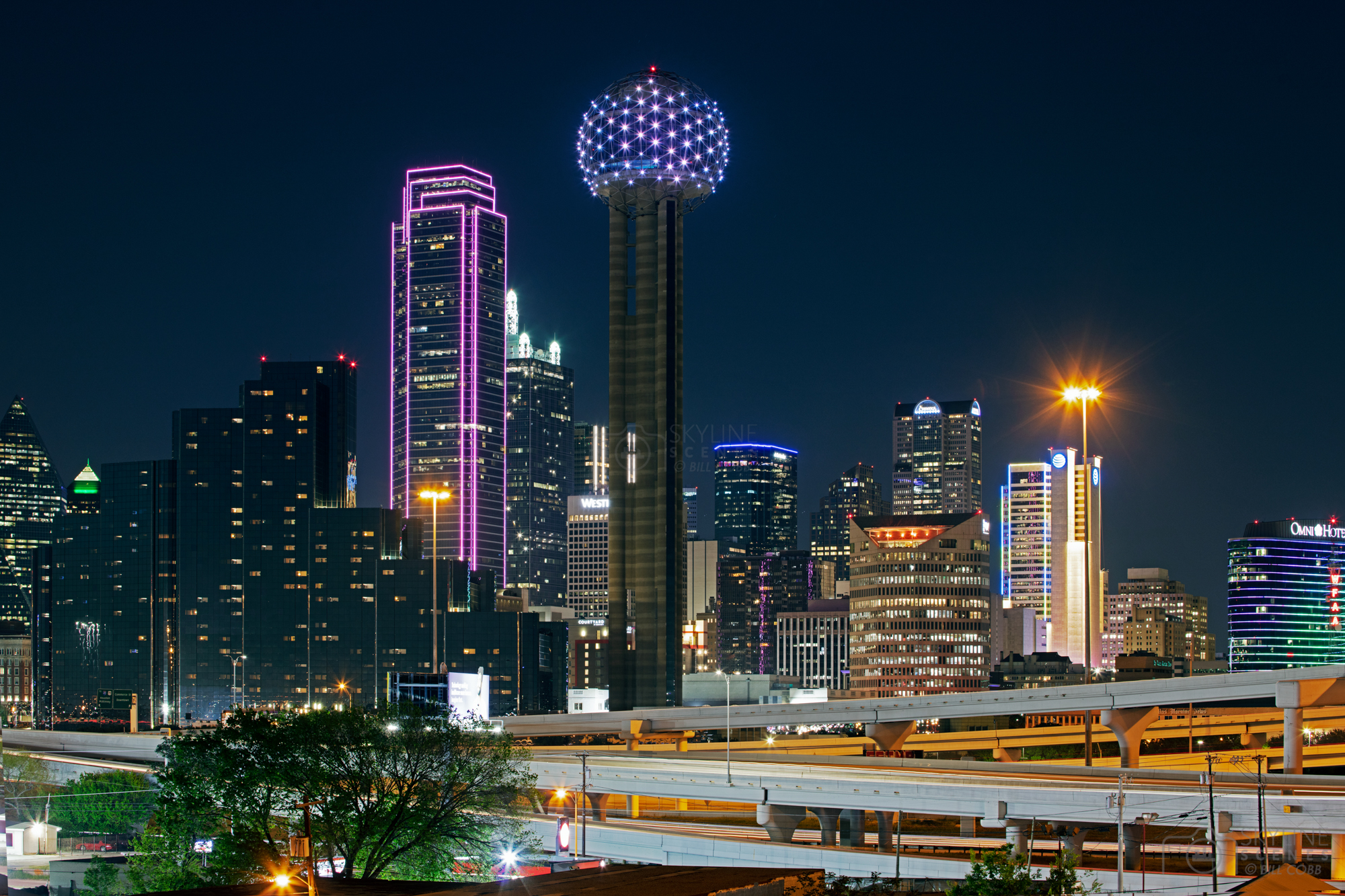 Bank of America Plaza and Reunion Tower and the skyline of downtown Dallas Texas at night.
